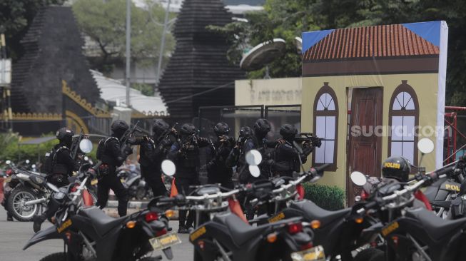 Anggota polisi melakukan simulasi penggerebekan dalam upacara upacara peresmian tim Perintis Presisi Polda Metro Jaya di Lapangan Presisi Polda Metro Jaya, Jakarta, Kamis (13/1/2022). [Suara.com/Angga Budhiyanto]