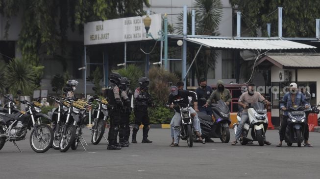 Anggota polisi melakukan simulasi pengamanan aksi balapan liar dalam upacara peresmian tim Perintis Presisi Polda Metro Jaya di Lapangan Presisi Polda Metro Jaya, Jakarta, Kamis (13/1/2022). [Suara.com/Angga Budhiyanto]