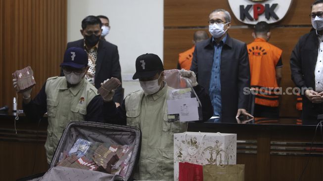 Penyidik menunjukkan barang bukti saat konferensi pers terkait operasi tangkap tangan (OTT) Bupati Penajam Paser Utara Abdul Gafur Mas'ud di Gedung Merah Putih KPK, Jakarta, Kamis (13/1/2021) malam. [Suara.com/Angga Budhiyanto]