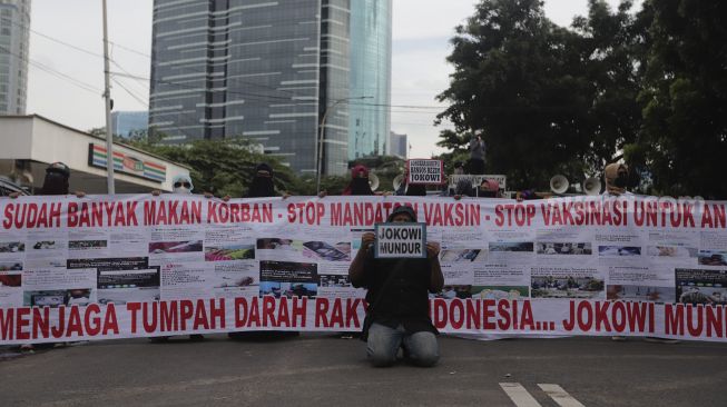 Massa yang tergabung dalam Aliansi Rakyat Menggugat (ARM) membawa spanduk dan poster saat melakukan aksi unjuk rasa di sekitar Gedung Komisi Pemberantasan Korupsi (KPK), Jakarta, Kamis (13/1/2022). [Suara.com/Angga Budhiyanto]