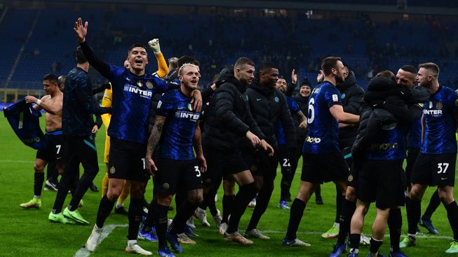 Para pemain Inter Milan merayakan dengan membawa trofi pemenang setelah memenangkan pertandingan sepak bola Piala Super Italia antara Inter melawan Juventus di Stadion Giuseppe-Meazza, Kamis (13/1/2022) dini hari WIB. [Foto AFP]