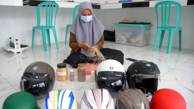 Pekerja memproduksi helm dari bahan limbah kelapa sawit (Green Composite Helmet) di PT Intertisi Material Maju (IMM), Situgede, Kota Bogor, Jawa Barat, Kamis (13/1/2022). ANTARA FOTO/Arif Firmansyah
