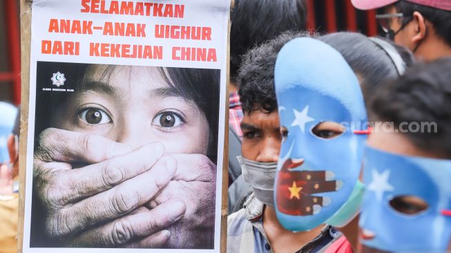 Poster-poster yang dibawa sejumlah massa aksi yang tergabung dalam Aliansi Mahasiswa Islam (AMI) saat menggelar aksi unjuk rasa di depan Kedutaan Besar China, Jakarta Selatan, Jumat (14/1/2022). [Suara.com/Alfian Winanto]