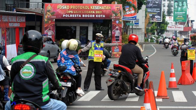 Anggota Polresta Bogor Kota bersama Dishub Kota Bogor mengatur arus lalu lintas saat pemberlakuan sistem ganjil genap di Simpang Baranangsiang, Kota Bogor, Jawa Barat, Sabtu (15/1/2022).  ANTARA FOTO/Arif firmansyah