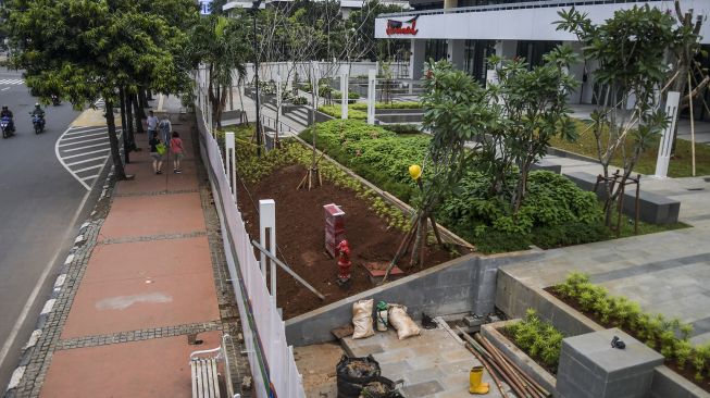 Warga melintas di samping proyek renovasi Gedung Sarinah di Jakarta, Sabtu (15/1/2022). ANTARA FOTO/Galih Pradipta
