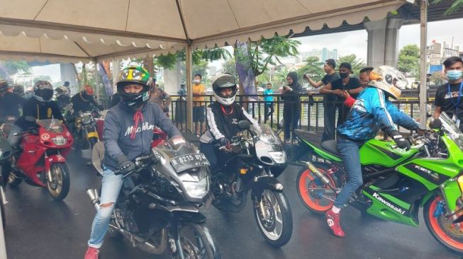 Ratusan pembalap motor jalanan atau yang bisa disebut joki meramaikan gelaran "street race" yang digelar oleh Polda Metro Jaya di Kawasan Taman Impian Jaya Ancol, Jakarta Utara, Minggu (16/1/2022) [ANTARA/Mentari Dwi Gayati].