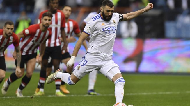 Pemain depan Real Madrid Karim Benzema melakukan tendangan penalti selama pertandingan sepak bola final Piala Super Spanyol antara Athletic Bilbao dan Real Madrid di Stadion Internasional King Fahd, Riyadh, Arab Saudi, pada (16/1/2022). [AFP]