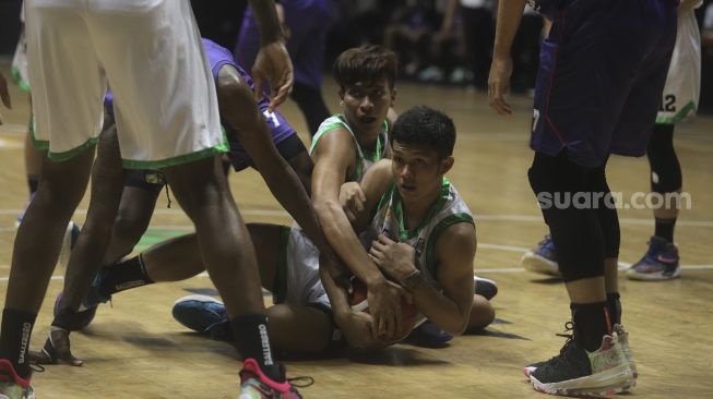 Pebasket Pacific Caesar Surabaya Dio Freedo Putra mengamankan bola saat bertanding melawan RANS PIK Basketball Club pada Indonesian Basketball League (IBL) 2022, di Hall Basket Gelora Bung Karno, Senayan, Jakarta, Senin (17/1/2022). [Suara.com/Angga Budhiyanto]