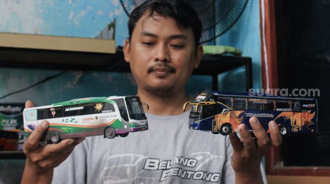 Andy Kunaryo (34) menunjukkan miniatur bus buatannya di Workshop Belang Bentong, Limo, Depok, Jawa Barat, Senin (17/1/2022). [Suara.com/Septian]