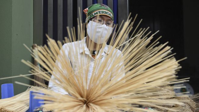 Seorang pekerja menata dupa untuk diwarnai di Desa Quang Phu Cau, Hanoi, Vietnam, pada (12/1/2022). [NHAC NGUYEN / AFP]