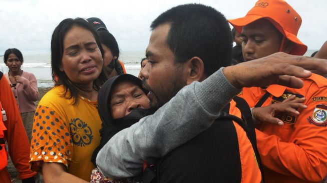 Keluarga korban menangis saat menyaksikan tim SAR gabungan mengevakuasi korban tenggelam di Pantai Wisata Anging Mammiri, Makassar, Sulawesi Selatan, Senin (17/1/2022). [ANTARA FOTO/Abriawan Abhe]