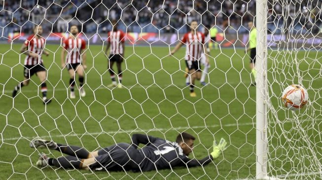 Penjaga gawang Athletic Bilbao Unai Simon kebobolan selama pertandingan sepak bola final Piala Super Spanyol antara Athletic Bilbao dan Real Madrid di Stadion Internasional King Fahd, Riyadh, Arab Saudi, pada (16/1/2022). [FAYEZ NURELDINE / AFP]