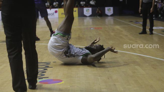 Pebasket Pacific Caesar Surabaya Akeem Garfield Ellis terjatuh saat bertanding melawan RANS PIK Basketball Club pada Indonesian Basketball League (IBL) 2022, di Hall Basket Gelora Bung Karno, Senayan, Jakarta, Senin (17/1/2022). [Suara.com/Angga Budhiyanto]