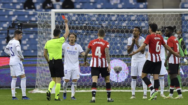 Wasit Spanyol Cesar Soto Grado (kedua kiri) menghadiahi bek Real Madrid Eder Militao (tengah kanan) dengan kartu merah selama pertandingan sepak bola final Piala Super Spanyol antara Athletic Bilbao dan Real Madrid di Stadion Internasional King Fahd, Riyadh, Arab Saudi, pada (16/1/2022). [FAYEZ NURELDINE / AFP]