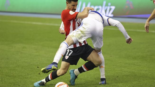 Bek Athletic Bilbao Yuri Berchiche bersaing dengan gelandang Real Madrid Luka Modric selama pertandingan sepak bola final Piala Super Spanyol antara Athletic Bilbao dan Real Madrid di Stadion Internasional King Fahd, Riyadh, Arab Saudi, pada (16/1/2022). [FAYEZ NURELDINE / AFP]