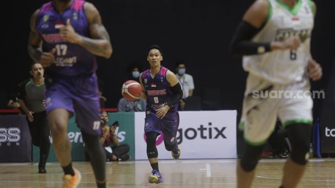 Pebasket RANS PIK Basketball Club Januar Kuntara (tengah) berlari membawa bola saat bertanding melawan Pacific Caesar Surabaya pada Indonesian Basketball League (IBL) 2022, di Hall Basket Gelora Bung Karno, Senayan, Jakarta, Senin (17/1/2022). [Suara.com/Angga Budhiyanto]