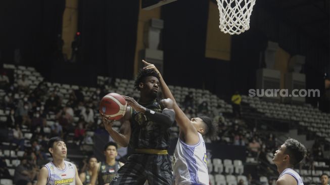 Pebasket West Bandits Combiphar Solo Dmonta Quoshawn Harris melakukan lay up melewati pemain Prawira Bandung pada pertandingan Seri 1 Jakarta Indonesian Basketball League (IBL) 2022 di Hall Basket Senayan, GBK, Jakarta, Senin (17/1/2022). [Suara.com/Angga Budhiyanto]