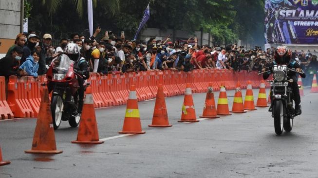 Peserta memacu motornya dalam street race yang diadakan Polda Metro Jaya di Ancol, Jakarta Utara, Minggu (16/1/2022). [ANTARA FOTO/Indrianto Eko Suwarso]