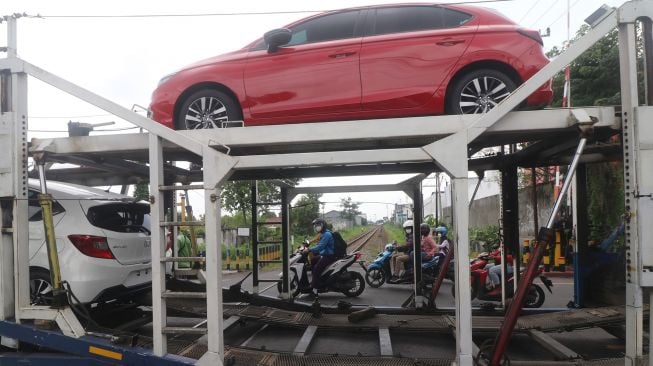 Truk pengangkut mobil tersangkut pada perlintasan kereta api di Kelurahan Balowerti, Kota Kediri, Jawa Timur, Selasa (18/1/2022).  ANTARA FOTO/Prasetia Fauzani