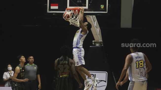 Pebasket Prawira Bandung Brian Michael Williams melakukan slamdunk pada pertandingan Seri 1 Jakarta Indonesian Basketball League (IBL) 2022 melawan West Bandits Combiphar Solo di Hall Basket Senayan, GBK, Jakarta, Senin (17/1/2022). [Suara.com/Angga Budhiyanto]