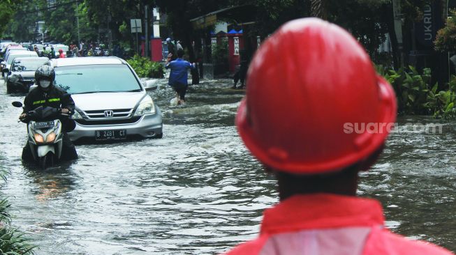 Kendaraan melintas di jalan raya Tanjung duren, Jakarta, Selasa (18/1). [Suara.com/Septian]
