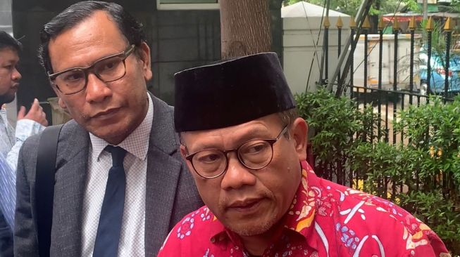Kuasa hukum Jerinx SID, Sugeng Teguh Santoso (mengenakan batik merah) di Pengadilan Negeri Jakarta Pusat, Selasa (18/1/2022). [Adiyoga Priyambodo/Suara.com]