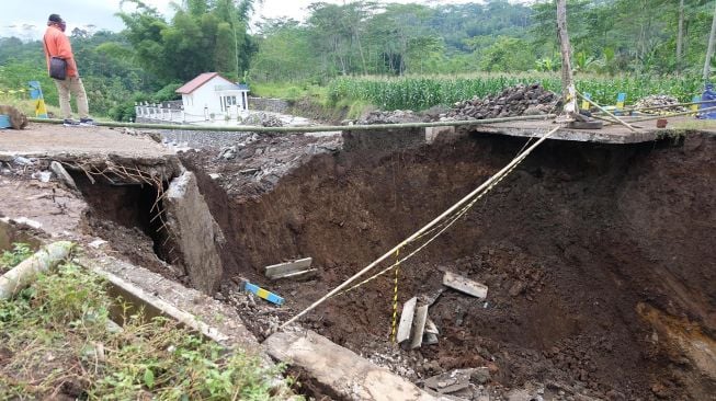 Warga menyaksikan jembatan ambruk di wilayah Mlondang Gandon, Kaloran, Temanggung, Jawa Tengah, Rabu (19/1/2022). ANTARA FOTO/Anis Efizudin
