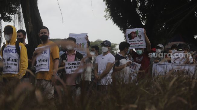 Pencari suaka asal Afghanistan melakukan aksi unjuk rasa di kawasan Monumen Nasional (Monas), Jakarta, Rabu (19/1/2022). [Suara.com/Angga Budhiyanto]