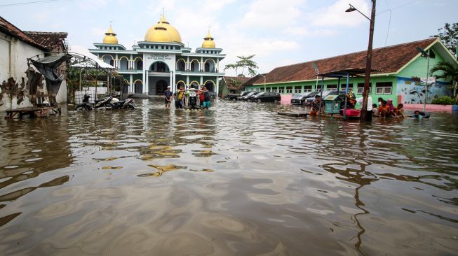 Warga melintasi banjir di Desa Rejoso, Kecamatan Rejoso, Pasuruan, Jawa Timur, Rabu (19/1/2022). ANTARA FOTO/Umarul Faruq
