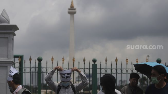 Pencari suaka asal Afghanistan melakukan aksi unjuk rasa di kawasan Monumen Nasional (Monas), Jakarta, Rabu (19/1/2022). [Suara.com/Angga Budhiyanto]