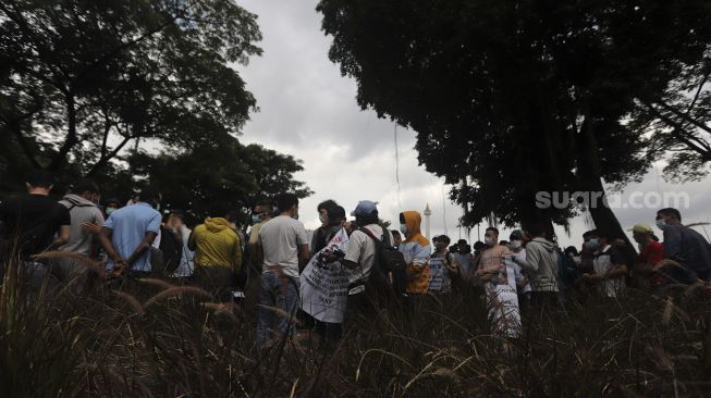 Pencari suaka asal Afghanistan melakukan aksi unjuk rasa di kawasan Monumen Nasional (Monas), Jakarta, Rabu (19/1/2022). [Suara.com/Angga Budhiyanto]