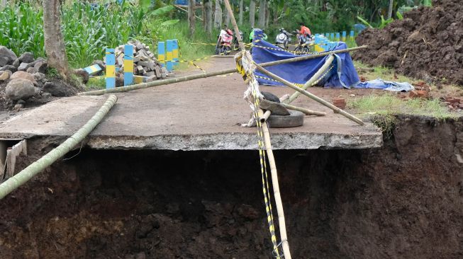 Warga menyaksikan jembatan ambruk di wilayah Mlondang Gandon, Kaloran, Temanggung, Jawa Tengah, Rabu (19/1/2022). ANTARA FOTO/Anis Efizudin
