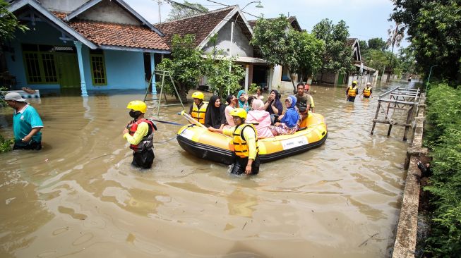 Warga melintasi banjir di Desa Rejoso, Kecamatan Rejoso, Pasuruan, Jawa Timur, Rabu (19/1/2022). ANTARA FOTO/Umarul Faruq
