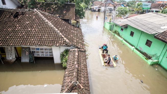 Warga melintasi banjir di Desa Rejoso, Kecamatan Rejoso, Pasuruan, Jawa Timur, Rabu (19/1/2022). ANTARA FOTO/Umarul Faruq
