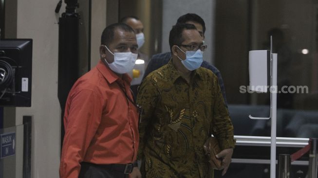 Hakim Pengadilan Negeri (PN) Surabaya Itong Isnaeni (kanan) berjalan menuju ruang pemeriksaan setibanya di Gedung Merah Putih KPK, Jakarta, Kamis (20/1/2022). [Suara.com/Angga Budhiyanto]