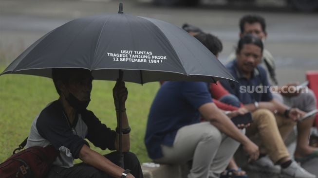 Massa yang tergabung dalam Jaringan Solidaritas Korban untuk Keadilan (JSKK) melakukan aksi Kamisan Ke-714 di seberang Istana Merdeka, Jakarta, Kamis (20/1/2022). [Suara.com/Angga Budhiyanto]