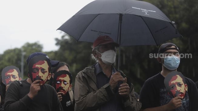 Massa yang tergabung dalam Jaringan Solidaritas Korban untuk Keadilan (JSKK) melakukan aksi Kamisan Ke-714 di seberang Istana Merdeka, Jakarta, Kamis (20/1/2022). [Suara.com/Angga Budhiyanto]