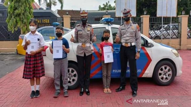 Sejumlah anak usia 6-11 tahun usai disuntik vaksin bersama petugas Satlantas Polres Sukoharjo naik mobil patroli di halaman Polres Sukoharjo, Kamis (20/1/2022) [ANTARA/Bambang Dwi Marwoto].