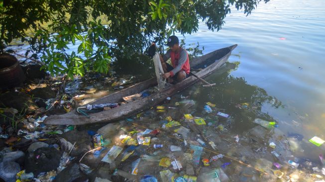 Nelayan memisahkan ikan tangkapannya di atas biduk di antara sampah, di tepian Danau Singkarak, Nagari Sumpu, Kabupaten Tanah Datar, Sumatera Barat, Kamis (20/1/2022). ANTARA FOTO/Iggoy el Fitra