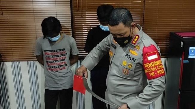 Kapolres Metro Tangerang Kombes Komarudin melihat sebuah senjata tajam (sajam) yang dibawa oleh dua pelajar yang diamankan, Selasa (18/1/2022). [Dok. Polisi]