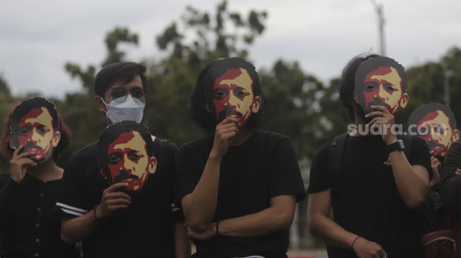 Massa yang tergabung dalam Jaringan Solidaritas Korban untuk Keadilan (JSKK) melakukan aksi Kamisan Ke-714 di seberang Istana Merdeka, Jakarta, Kamis (20/1/2022). [Suara.com/Angga Budhiyanto]