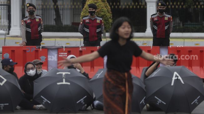 Polisi melakukan penjagaan aksi Kamisan Ke-714 di seberang Istana Merdeka, Jakarta, Kamis (20/1/2022). [Suara.com/Angga Budhiyanto]