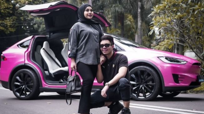 Aurel Hermansyah dan Atta Halilintar berpose di depan mobil Tesla untuk Baby A. (Instagram/attahalilintar)