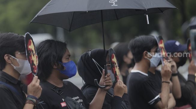 Massa yang tergabung dalam Jaringan Solidaritas Korban untuk Keadilan (JSKK) melakukan aksi Kamisan Ke-714 di seberang Istana Merdeka, Jakarta, Kamis (20/1/2022). [Suara.com/Angga Budhiyanto]