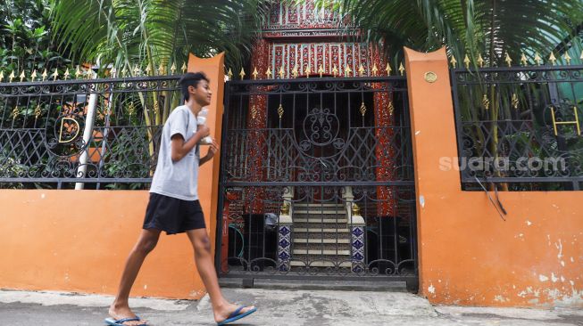 Warga melintas di depan Rumah Gadang milik Artis Dorce Gamalama di Jatibening, Bekasi, Jawa Barat, Jumat (21/1/2022). [Suara.com/Alfian Winanto]