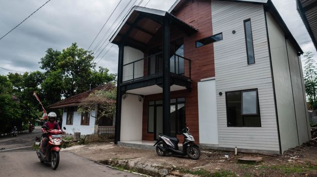 Warga melintas di depan rumah tahan gempa di Rangkasbitung, Lebak, Banten, Jumat (21/1/2022).  ANTARA FOTO/Muhammad Bagus Khoirunas