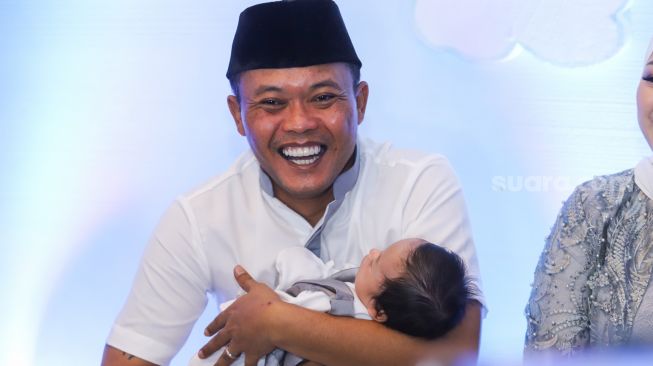 Komedian Entis Sutisna atau Sule sambil menggendong putranya, Adzam Adriansyah Sutisna saat menggelar jumpa pers usai acara akikah di Tambun, Bekasi, Jawa Barat, Jumat (21/1/2022). [Suara.com/Alfian Winanto]