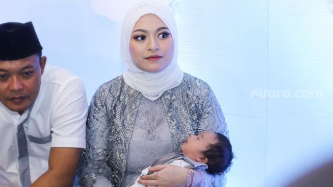Nathalie Holscher sambil menggendong putranya, Adzam Adriansyah Sutisna saat menggelar jumpa pers usai acara akikah di Tambun, Bekasi, Jawa Barat, Jumat (21/1/2022). [Suara.com/Alfian Winanto]