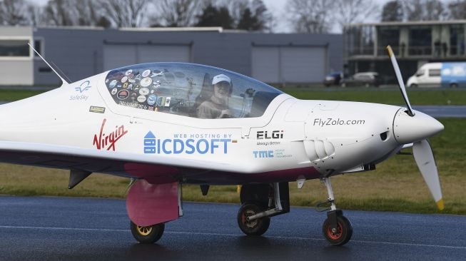 Pilot remaja Belgia-Inggris Zara Rutherford menaiki pesawat Ultralight Shark mendarat kembali di akhir perjalanan solo keliling dunianya di Kota Kortrijk, Belgia, pada (20/1/2022). [JOHN THYS / AFP]