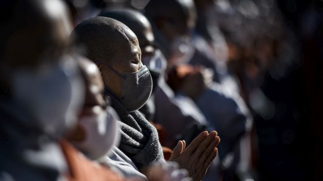 Anggota Ordo Jogye, sekte Buddha terbesar di Korea Selatan, berdoa saat mengadakan rapat umum di Kuil Jogye, Seoul, Jumat (21/1/2022). [ANTHONY WALLACE / AFP]